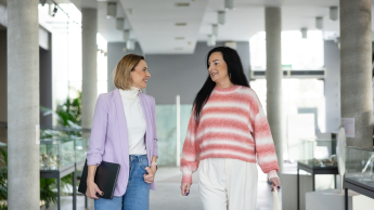 Zarządzanie zasobami ludzkimi | Studia podyplomowe w Opolu | Uniwersytet WSB Merito Opole: Główna grafika: Opole - studia podyplomowe -  Zarządzanie kapitałem ludzkim - Dwie kobiety idące korytarzem