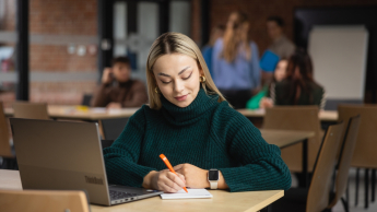 Kryminologia i kryminalistyka | Studia I stopnia w Opolu | Uniwersytet WSB Merito Opole: Główna grafika: Opole - studia I stopnia - specjalność kryminologia i kryminalistyka - Dziewczyna korzystająca z laptopa, tworzy notatki