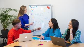 Pedagogika opiekuńczo-wychowawcza z pedagogiką Montessori | Studia I stopnia w Opolu | Uniwersytet WSB Merito Opole: Główna grafika: Opole - studia I stopnia licencjackie - Pedagogika: Pedagogika: Pedagogika opiekuńczo-wychowawcza z pedagogiką Montessori- studenci rozmawiają w sali lekcyjnej i piszą na tablicy markerem