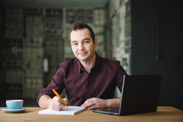 Kadry i płace | Studia podyplomowe w Opolu | Uniwersytet WSB Merito Opole: Mężczyzna tworzący notatki