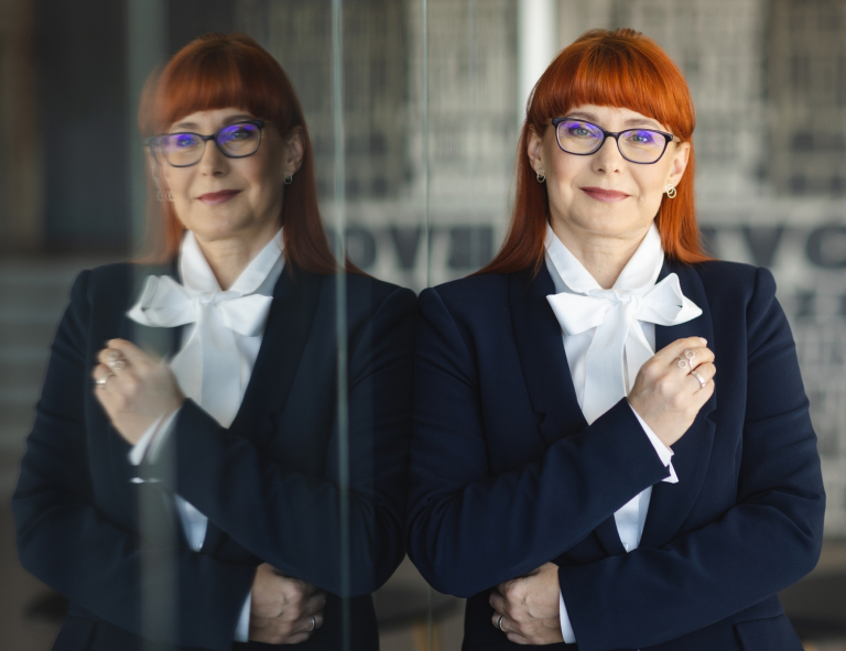 Rachunkowość od podstaw | Studia podyplomowe w Opolu | Uniwersytet WSB Merito Opole: Kobieta w marynarce stojąca w kawiarni
