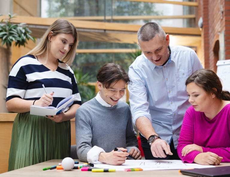 Finanse małych i średnich przedsiębiorstw | Studia I stopnia w Opolu | Uniwersytet WSB Merito Opole: Główna grafika: Opole - studia I stopnia - specjalność Finanse małych i średnich przedsiębiorstw - Grupa osób pracująca nad projektem pod okiem wykładowcy