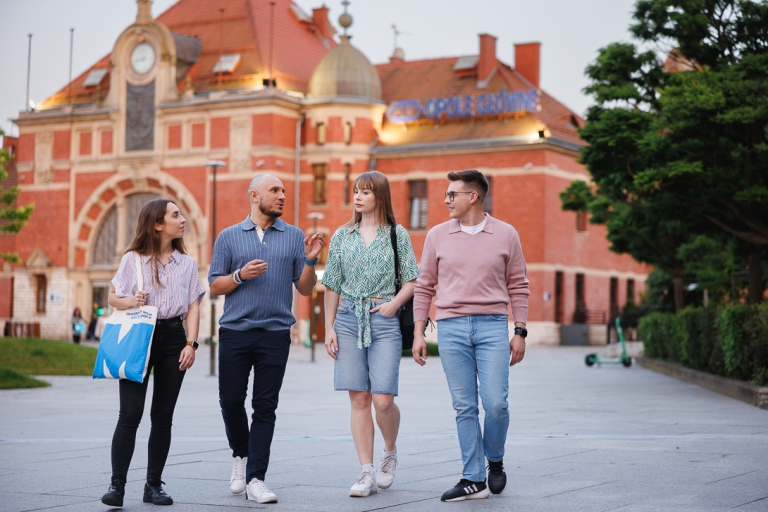 ABC studenta | Uniwersytet WSB Merito Opole: Grafika główna: WSB Merito Opole, dla nowych studentów, czwórka studentów idzie przez starówkę w Opolu