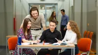 Finanse publiczne i podatki | Studia II stopnia ze studiami podyplomowymi  | Uniwersytet WSB Merito w Poznaniu: Grupa studentów pracuje przy stole