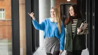 Zaawansowane systemy baz danych | Studia II stopnia w Poznaniu | Uniwersytet WSB Merito w Poznaniu: Dwie studentki, kolorowo ubrane spacerują po korytarzu uczelni WSB Merito w Poznaniu 
