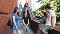 Manager bezpieczeństwa biznesu | Studia I stopnia w Poznaniu | Uniwersytet WSB Merito w Poznaniu: Grupa studentów rozmawiających na schodach starego browaru