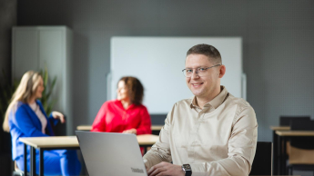 Bibliotekoznawstwo | Studia podyplomowe w Poznaniu | Uniwersytet WSB Merito w Poznaniu: Mężczyzna przy laptopie w sali wykładowej.
