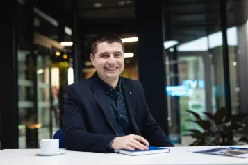 Wyniki wyszukiwania | Uniwersytet WSB Merito w Poznaniu: Uczestnik studiów MBA siedzi na korytarzu przy stole uczelni- Uniwersytet WSB Merito w poznaniu