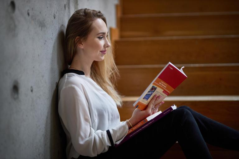 Studia jednolite magisterskie w Poznaniu | Uniwersytet WSB Merito w Poznaniu: Studentka, czyta książkę