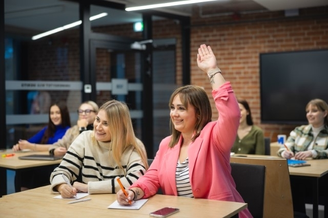Studia II stopnia z podyplomowymi w Poznaniu | Uniwersytet WSB Merito w Poznaniu: Studentki biorą aktywny udział w zajęciach, jedna z nich z uśmiechem podnosi rękę