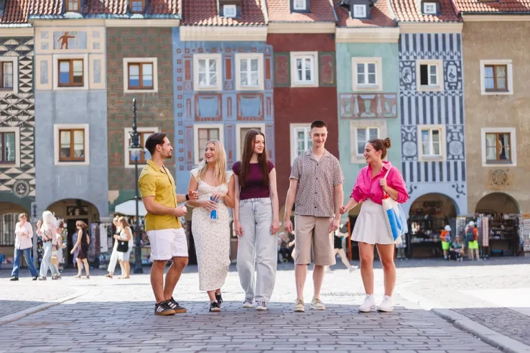 Psychologia | Studia jednolite magisterskie w Poznaniu | Uniwersytet WSB Merito w Poznaniu: Grafika główna: WSB Merito Poznań, dla nowych studentów, pięcioro studentów idzie przez Stary Rynek w Poznaniu