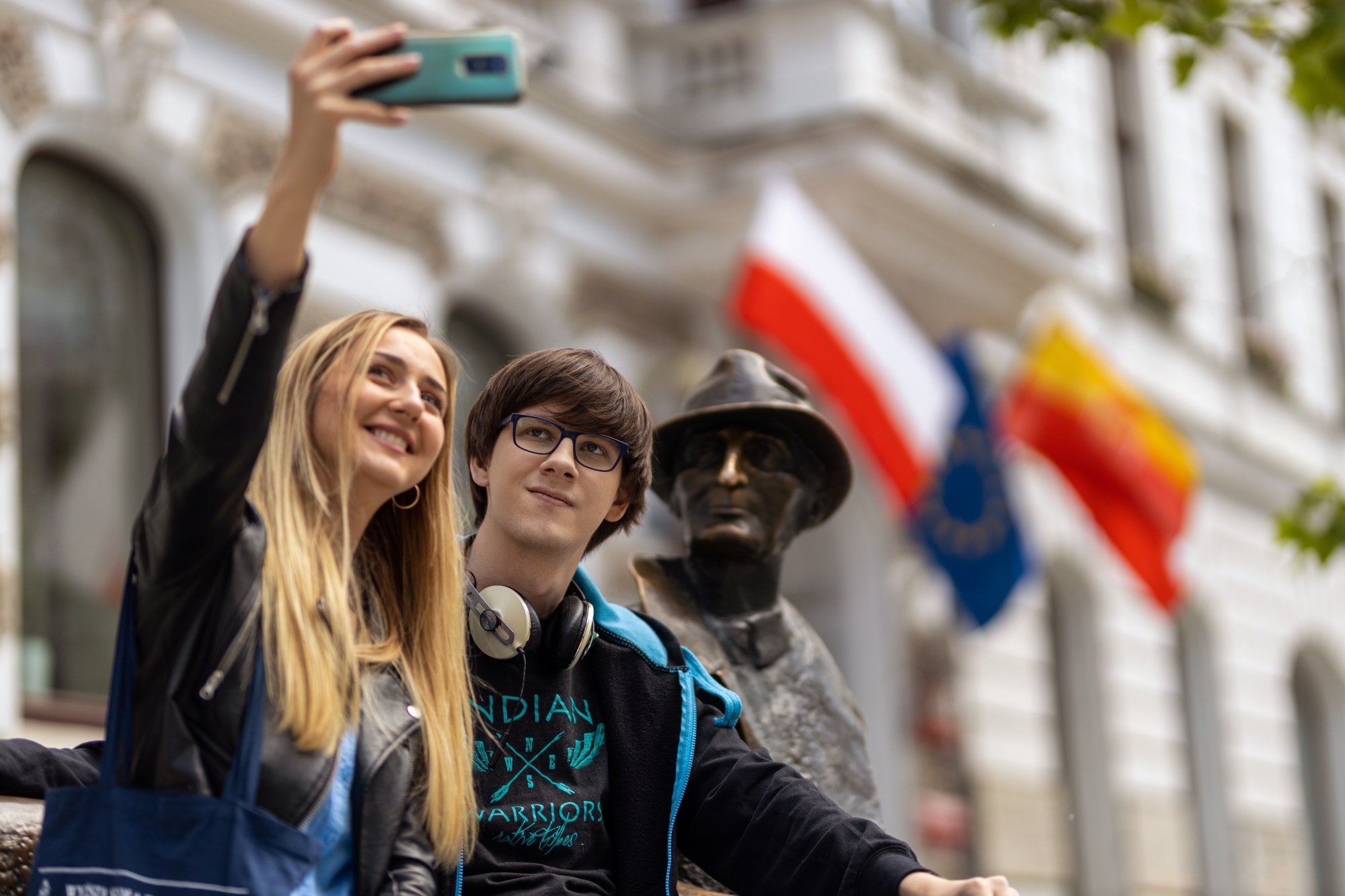 Dwie osoby robiące selfie z posągiem