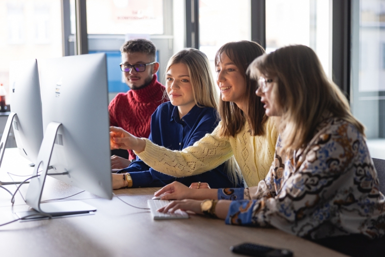 Konferencje i seminaria | Uniwersytet WSB Merito: Grupa studentów przed monitorem komputera