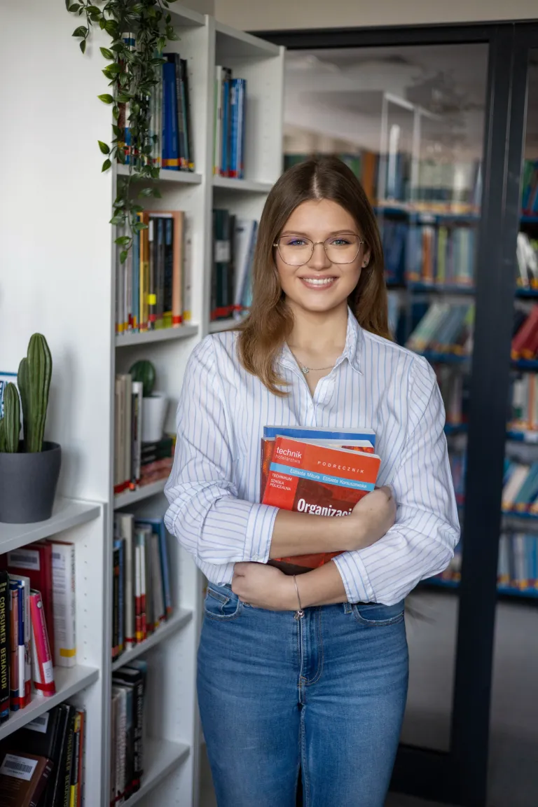 Studiowanie dwóch kierunków. Rady dla studentów jak studiować dwa kierunki jednocześnie. | Uniwersytet WSB Merito: Dziewczyna trzymająca książki w dłoni