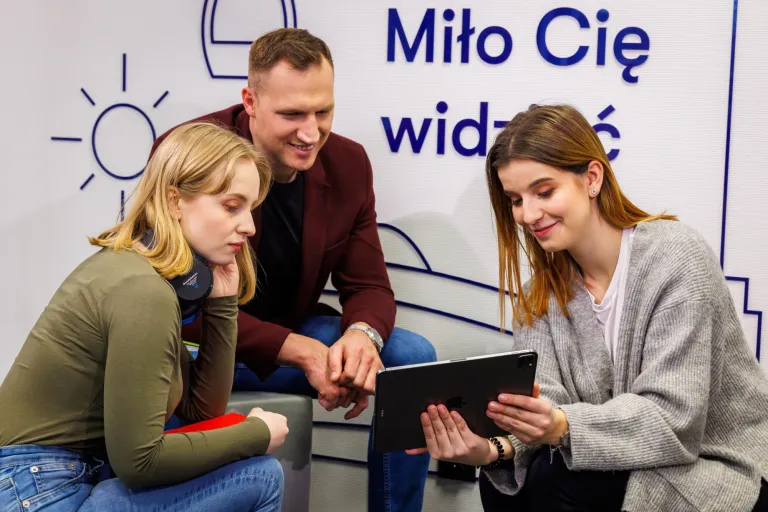 Strach ma wielkie oczy, czyli AI na rynku pracy | Blog "okiem praktyków" | Uniwersytet WSB Merito: Troje młodych ludzi wpatrujących się w tableta