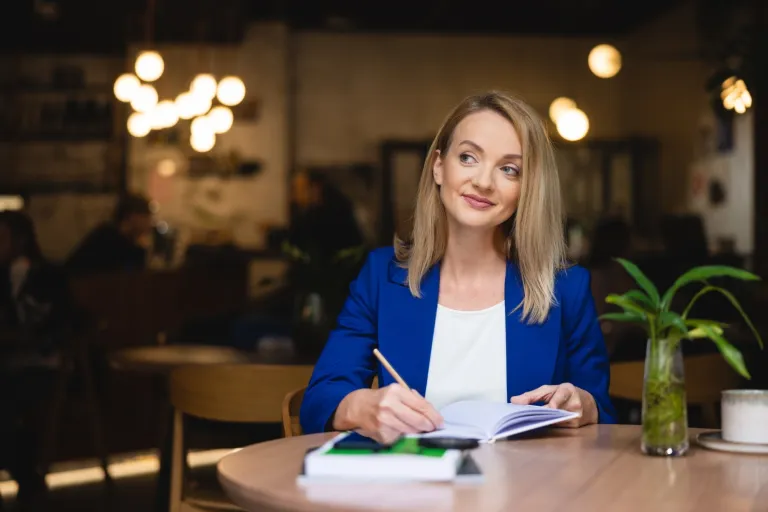 Studia magisterskie z podyplomowymi – 2 dyplomy w 2 lata | Uniwersytet WSB Merito: Kobieta notująca w zeszycie