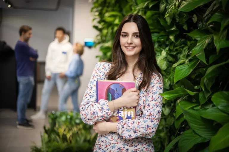 Jak dobrze przygotować się do studiów? 5 rad dla przyszłych studentów | Uniwersytet WSB Merito: Dziewczyna z notesem na zielonym tle