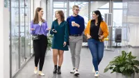 Dydaktyka języków obcych | Studia podyplomowe w Szczecinie | Uniwersytet WSB Merito Szczecin: Studenci rozmawiają spacerując korytarzem podczas przerwy.
