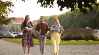 Psychologia społeczna | Studia jednolite magisterskie w Szczecinie | Uniwersytet WSB Merito Szczecin: Troje studentów Uniwersytetu WSB Merito Szczecin spaceruje po parku, trzymając kawę i rozmawiając.