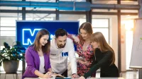 Czworo studentów Uniwersytetu WSB Merito wspólnie pracuje nad projektem przy tablecie.