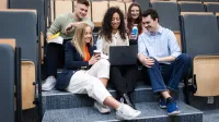 Zarządzanie | Studia II stopnia w Szczecinie | Uniwersytet WSB Merito Szczecin: Studenci pracują zespołowo przy laptopie w auli wykładowej.