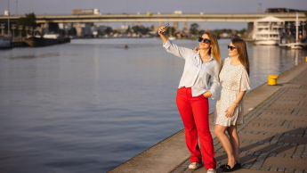 Hotelarstwo i gastronomia | Studia I stopnia w Szczecinie | Uniwersytet WSB Merito Szczecin: Dwie studentki Uniwersytetu WSB Merito Szczecin robią selfie nad Odrą w słoneczny dzień.