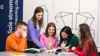 Przygotowanie pedagogiczne – dla nauczycieli przedmiotów lub zajęć prowadzonych w szkole podstawowej i ponadpodstawowej | Studia podyplomowe w Szczecinie | Uniwersytet WSB Merito Szczecin: Grupa studentów Uniwersytetu WSB Merito wspólnie pracuje nad materiałami, ucząc się i wymieniając pomysły w nowoczesnej przestrzeni edukacyjnej.