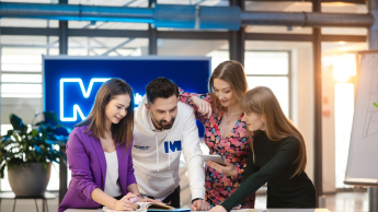 Czworo studentów Uniwersytetu WSB Merito wspólnie pracuje nad projektem przy tablecie.