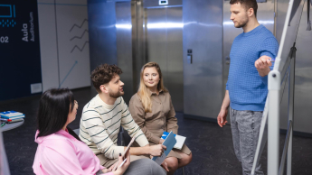 Pedagogika pracy i zarządzania zasobami ludzkimi | Studia I stopnia w Szczecinie | Uniwersytet WSB Merito Szczecin: Główna grafika: Grupa studentów w korytarzu uczelni