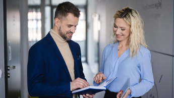 Negocjacje w biznesie | Studia podyplomowe w Szczecinie | Uniwersytet WSB Merito Szczecin: Uczestnicy MBA na korytarzu uczelni, kobieta i mężczyzna- Uniwersytet WSB Merito Szczecin
