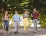 Potrafię się obronić. Odbierz bezpłatnie 7-odcinkowy wideo podcast o technikach redukowania stresu | Aktualności | Uniwersytet WSB Merito Szczecin: Czworo studentów spaceruje alejką w parku, rozmawiając i uśmiechając się.