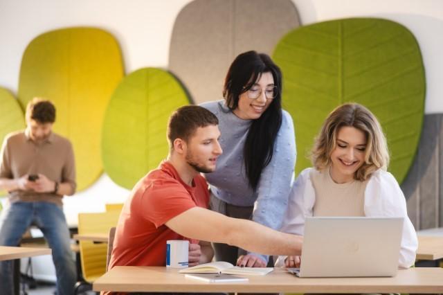 Nasz kampus | Uniwersytet WSB Merito Szczecin: Studenci Uniwersytetu WSB Merito pracujący wspólnie przy laptopie w przestrzeni studenckiej.