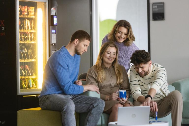 Studia MBA w Szczecinie | Uniwersytet WSB Merito Szczecin: Czworo studentów Uniwersytetu WSB Merito siedzi w strefie relaksu, pracując wspólnie przy laptopie.