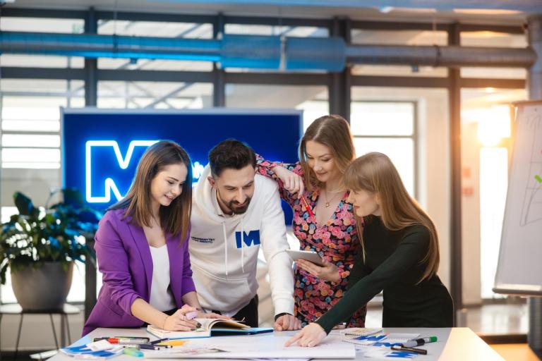 Biznes | Uniwersytet WSB Merito Szczecin: Czworo studentów Uniwersytetu WSB Merito wspólnie pracuje nad projektem przy tablecie.