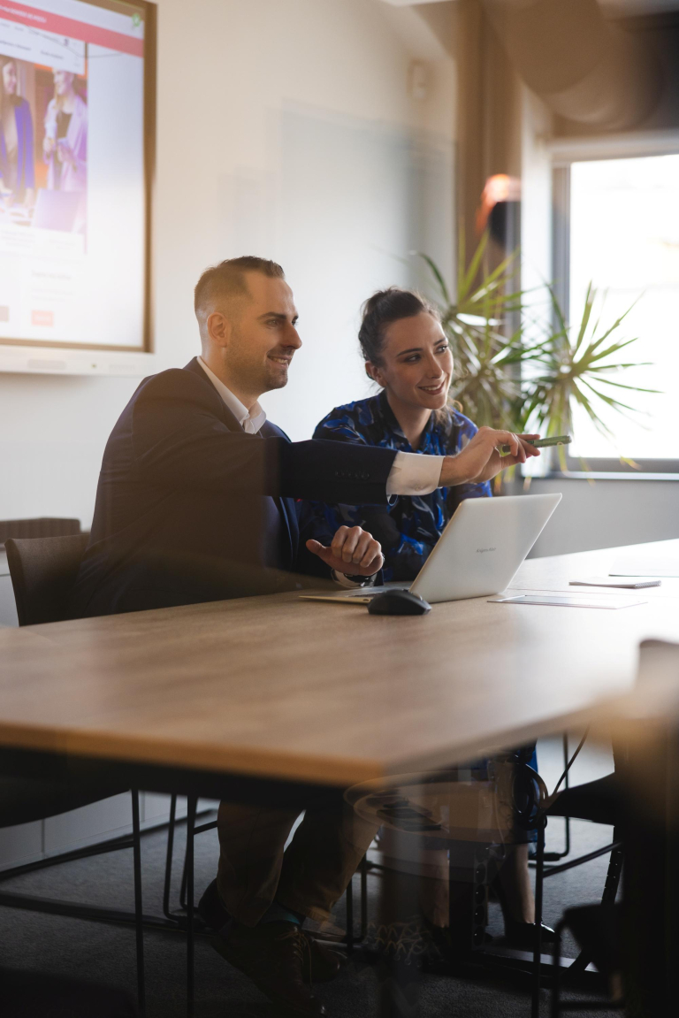 SAP S/4HANA – nowoczesny system ERP | Studia podyplomowe w Szczecinie | Uniwersytet WSB Merito Szczecin: Dwie osoby pracują przy laptopie, omawiając prezentację.