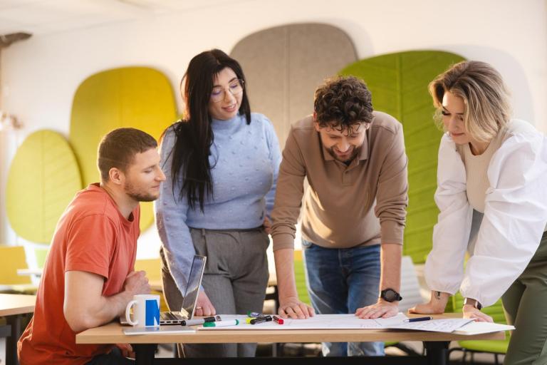 Zarządzanie kryzysowe i ochrona ludności | Studia II stopnia w Szczecinie | Uniwersytet WSB Merito Szczecin: Grupa studentów pracuje zespołowo nad projektem w przyjaznej przestrzeni Uniwersytetu WSB Merito.