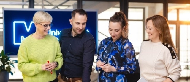 Awanse naukowe | Uniwersytet WSB Merito Szczecin: Studenci realizujący projekt przy stole na uzczelni WSB Merito