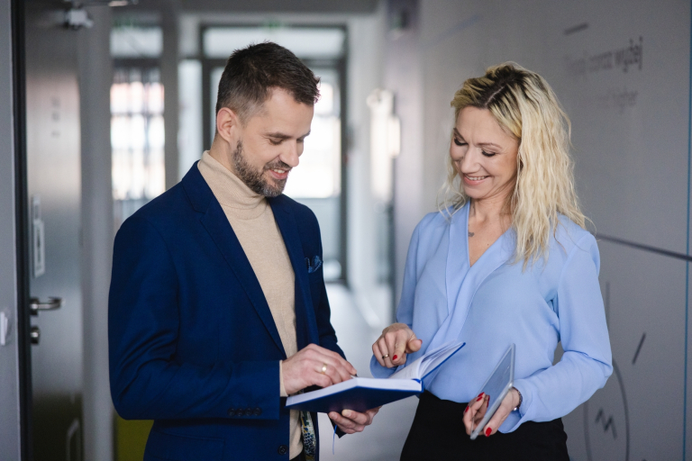 Studia MBA w Szczecinie | Uniwersytet WSB Merito Szczecin: Uczestnicy MBA na korytarzu uczelni, kobieta i mężczyzna- Uniwersytet WSB Merito Szczecin