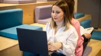 Sprzedaż i e-commerce | Uniwersytet WSB Merito w Toruniu: studentka z laptopem na kolanach
