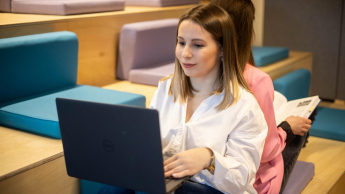 Sprzedaż i e-commerce | Uniwersytet WSB Merito w Toruniu: studentka z laptopem na kolanach