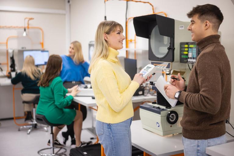 Poznaj nas | Uniwersytet WSB Merito w Toruniu: dwoje uśmiechniętych studentów w uniwersyteckim laboratorium inżynierii
