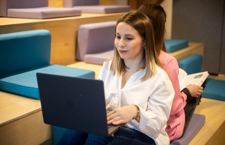 Cyfrowy uniwersytet | Uniwersytet WSB Merito w Toruniu: studentka z laptopem na kolanach