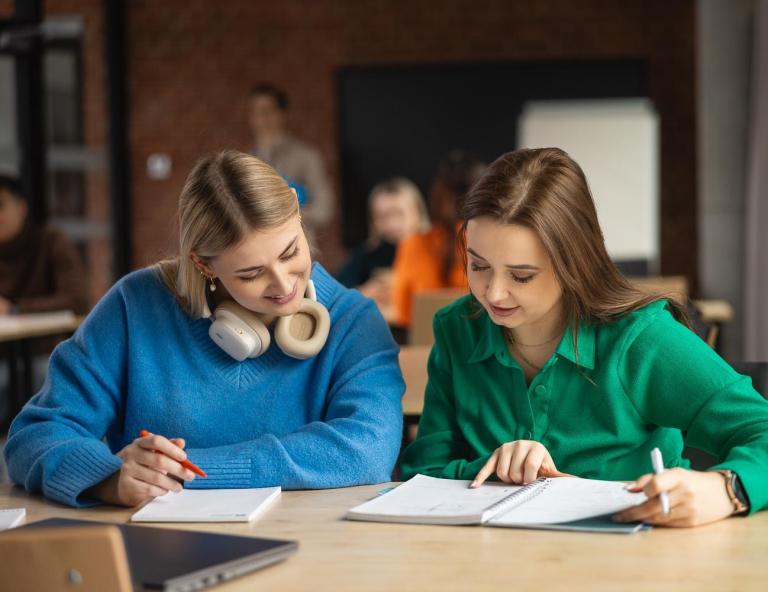 Przeniesienie z innej uczelni w Toruniu | Uniwersytet WSB Merito w Toruniu: dwie studentki przy biurku, współpraca