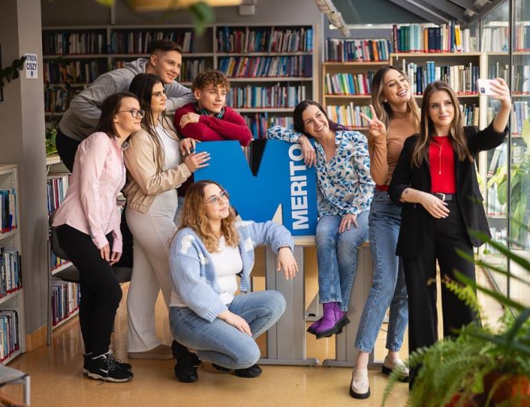 Stypendia i zniżki | Uniwersytet WSB Merito w Toruniu: Grafika głóna: Samorząd studencki - Toruń - Uniwersytet WSB Merito w Toruniu - grupa uśmiechniętych studentów w bibliotece