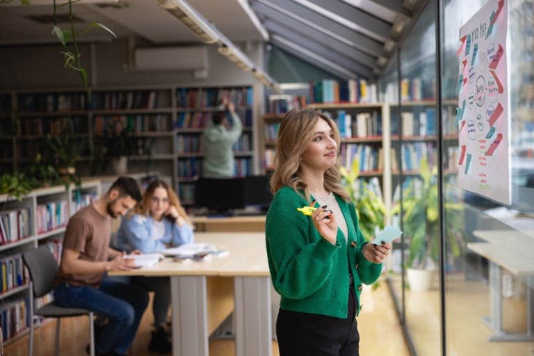 Marketing i sprzedaż | Studia II stopnia ze studiami podyplomowymi w Toruniu | Uniwersytet WSB Merito w Toruniu: Główna grafika: Toruń - studia I stopnia - grupa uśmiechniętych studentów w bibliotece