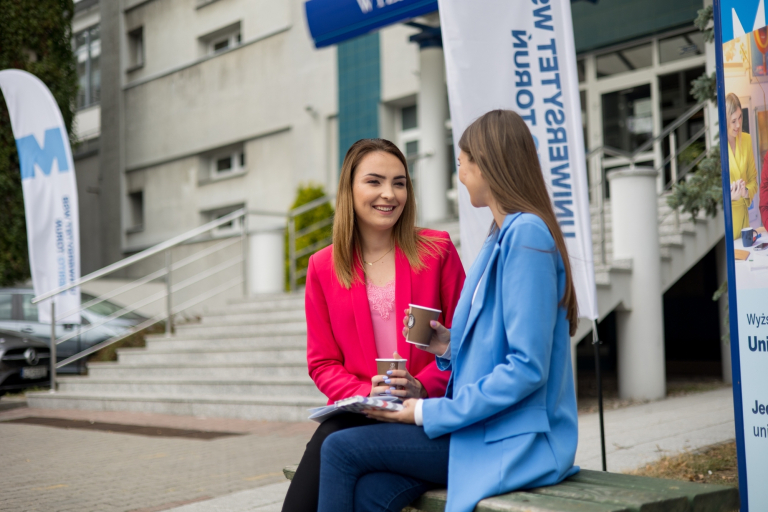 Główna grafika: Toruń - studia licencjackie - studenci podczas rozmowy pod budynkiem uczelni