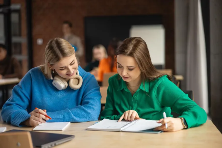 Web Application Developer | Studia I stopnia w Toruniu | Uniwersytet WSB Merito w Toruniu: dwie studentki przy biurku, współpraca