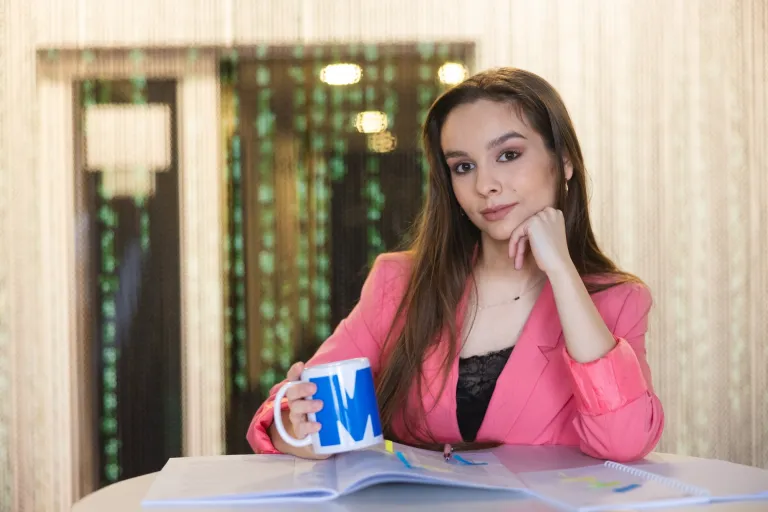 Logistyka | Studia I stopnia w Toruniu | Uniwersytet WSB Merito w Toruniu: Główna grafika: Toruń - studia I stopnia - studentka trzymająca kubek z logiem Merito