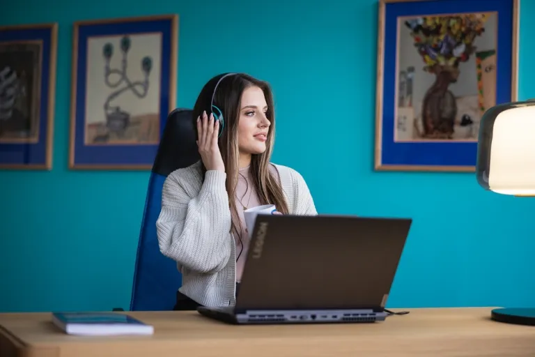 Home Design | Studia I stopnia w Toruniu | Uniwersytet WSB Merito w Toruniu: Główna grafika: Toruń - studia I stopnia - studentka przy laptopie z słuchawkami na głowie