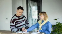 Zarządzanie produktem | Studia II stopnia w Warszawie | Uniwersytet WSB Merito Warszawa: Dwoje pracowników podczas notowania
